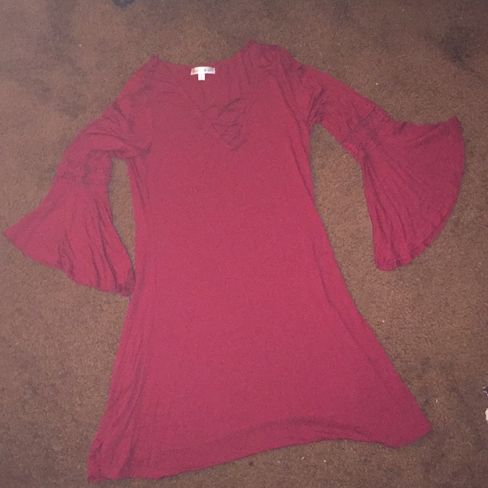 A red dress that is half sleeved flared sleeves .